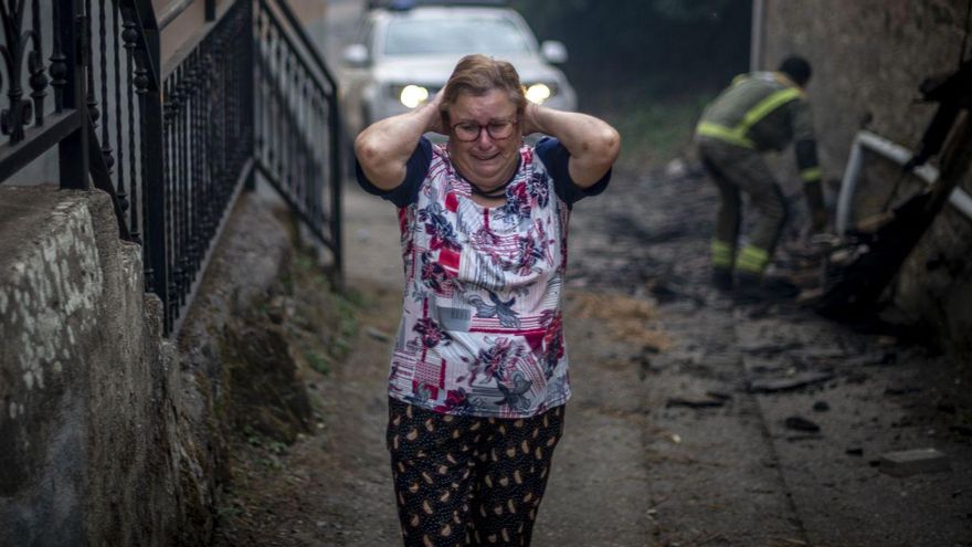 Una mujer, vecina de Alixo (O Barco) se echa las manos a la cabeza al ver, durante la mañana de ayer, las casas calcinadas de la localidad ourensana. | // BRAIS LORENZO