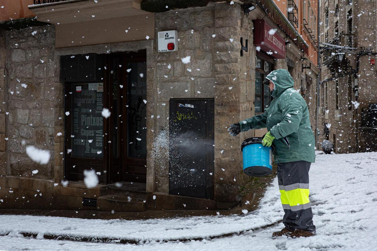 Una operaria del ayuntamiento de Solsona esparce sal por las calles.