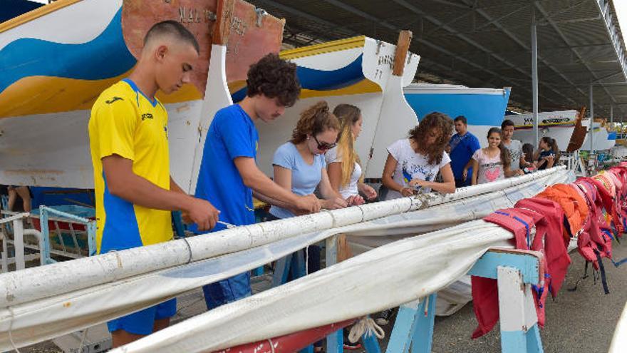 Los participantes del curso preparan la vela antes de zarpar.