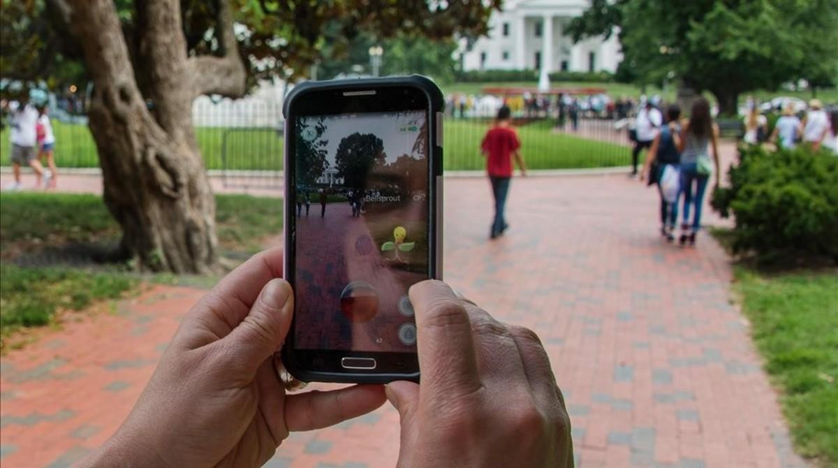 fcasals34678914 a woman holds up her cell phone as she plays the pokemon go 160714190612