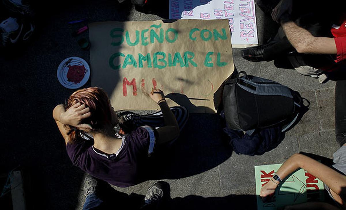 Una noia escriu una pancarta aquest divendres a la concentració de la Puerta del Sol.