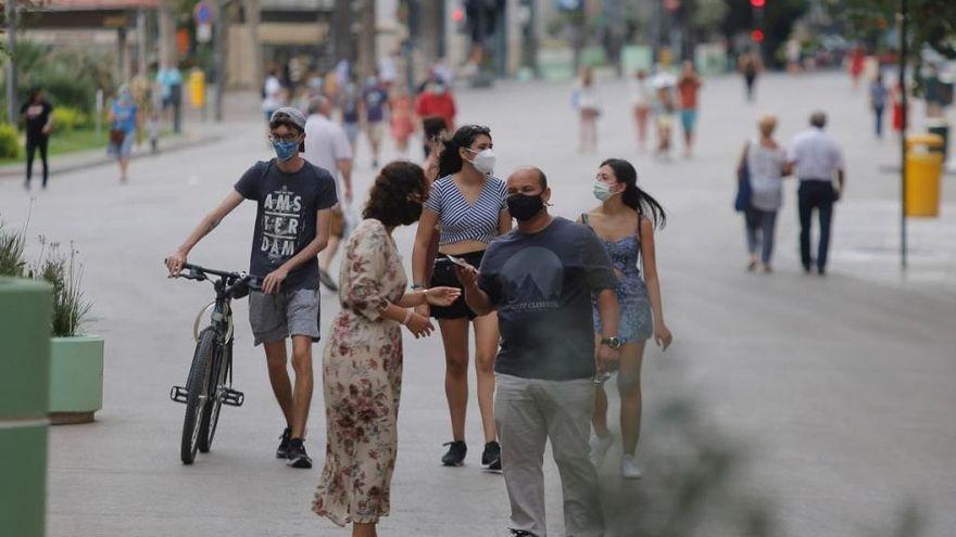 Varias personas pasean con las mascarillas puestas en València