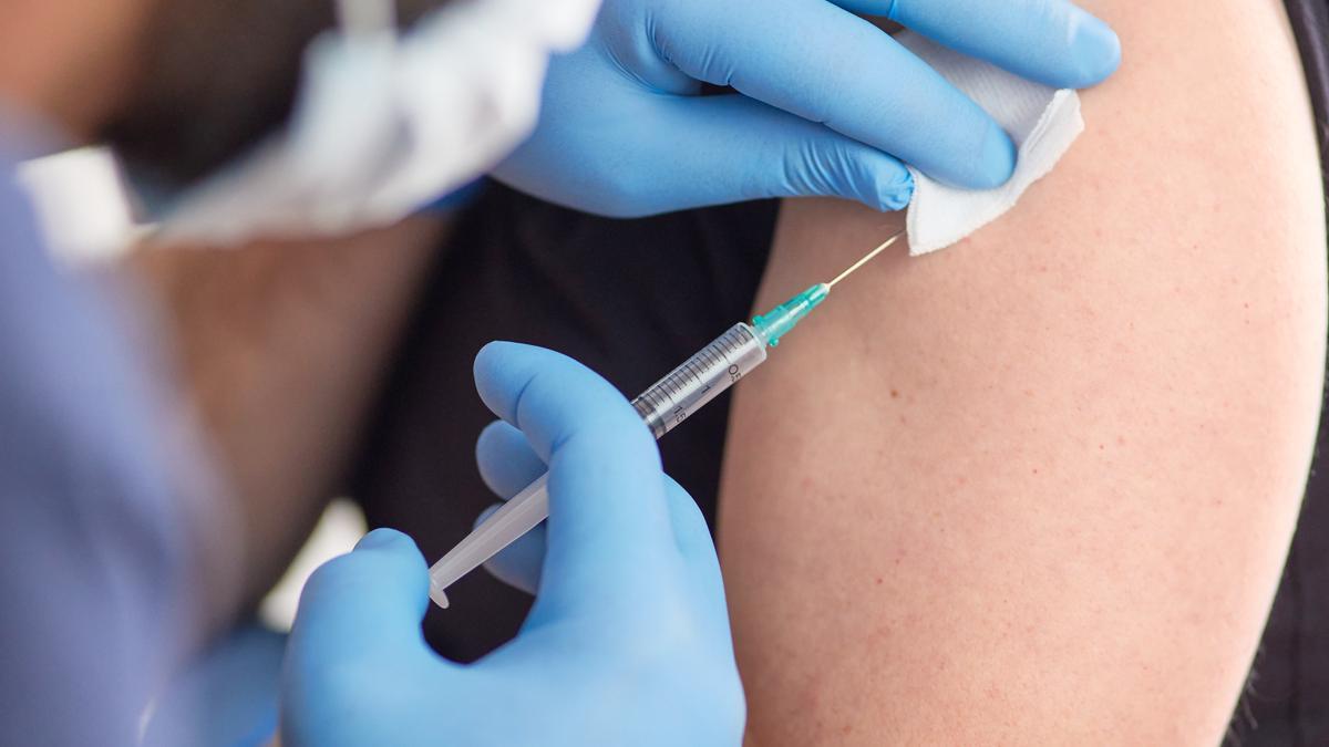Personal sanitario aplicando una vacuna, en imagen de archivo