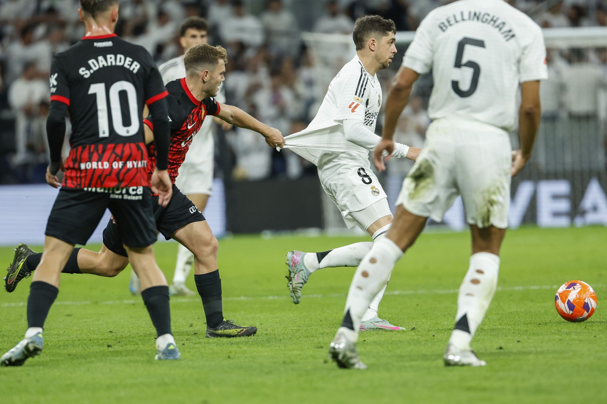 MADRID, 14/05/2025.- El centrocampista uruguayo del Real Madrid Federico Valverde (d) intenta escaparse con el balón durante el partido de la jornada 36 de LaLiga de fútbol que Real Madrid y RCD Mallorca disputan este miércoles en el estadio Santiago Bernabéu. EFE/Chema Moya