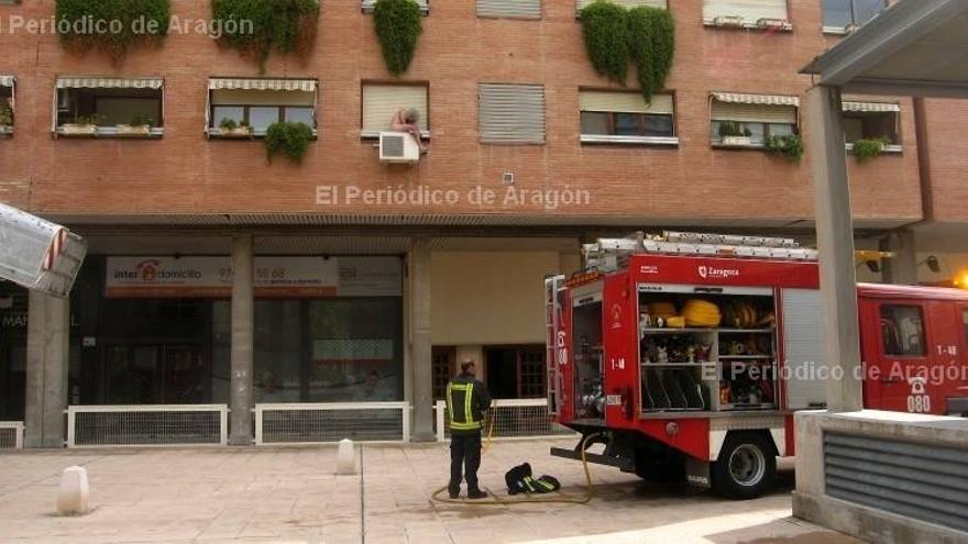 Un incendio obliga a un vecino a esperar a los bomberos sobre un aparato de aire acondicionado