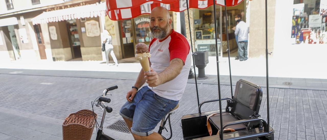 Iván Noval, con cucurucho y en carrito, junto a su negocio en Gijón. | Marcos León