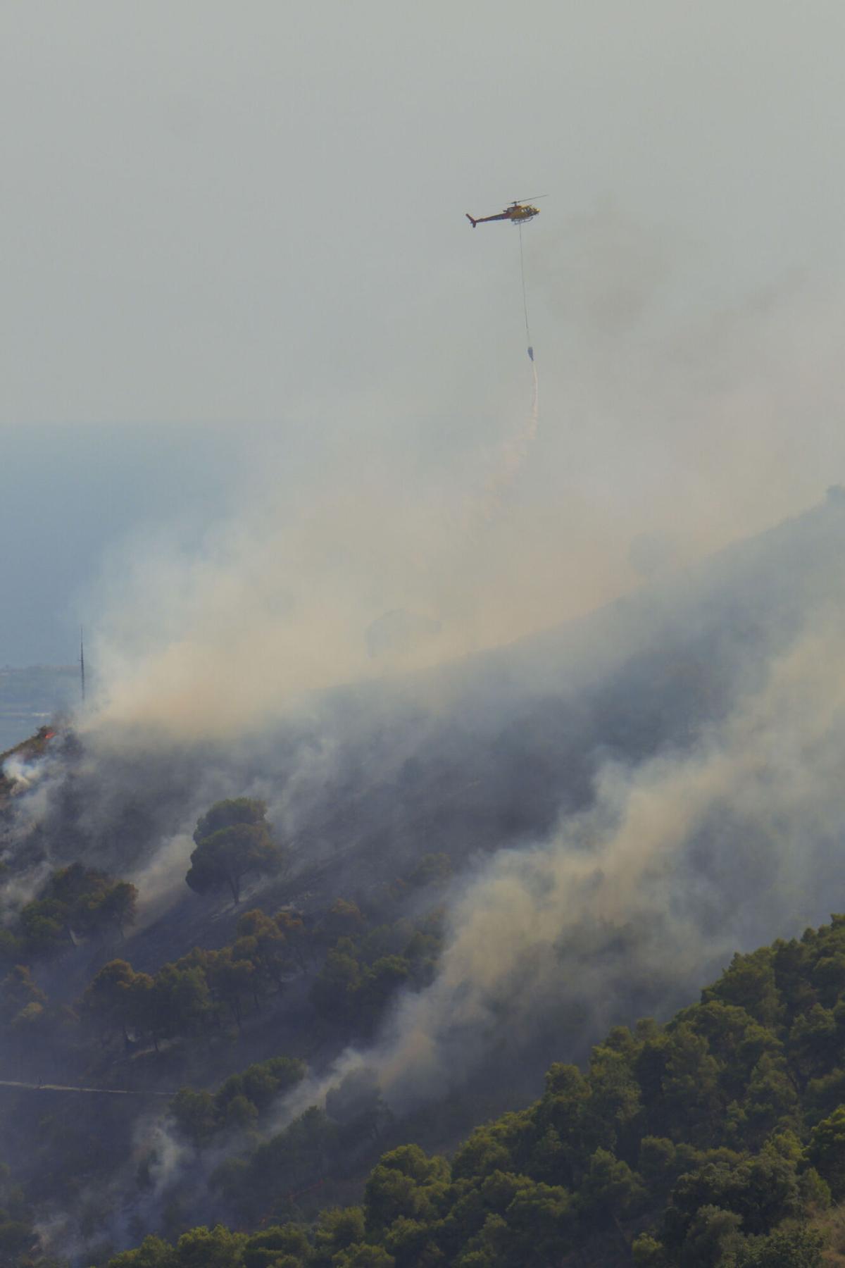 Un helicóptero carga agua para combatir el incendio forestal declarado en la montaña de Sant Pere Màrtir, en Collserola. Un helicóptero carga agua para combatir el incendio forestal declarado en la montaña de Sant Pere Màrtir, en Collserola.