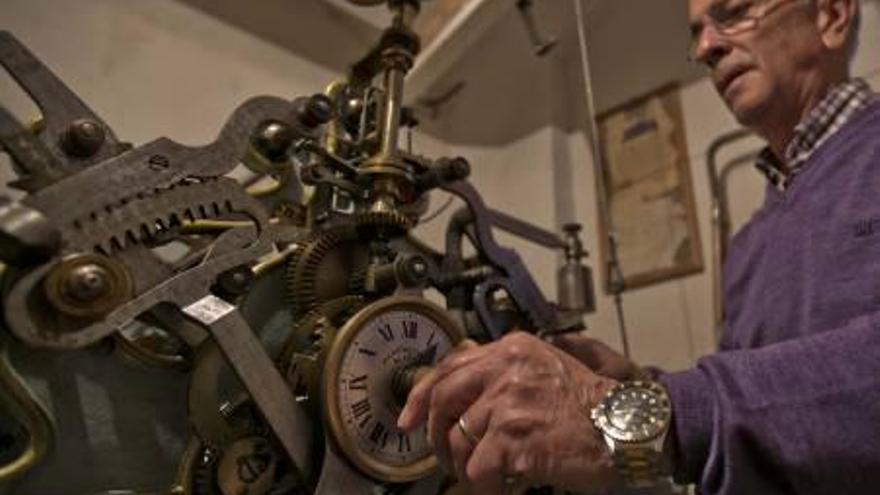 Paco Hernández, de Joyería Gómez, revisando el reloj de la Plaça de Baix.