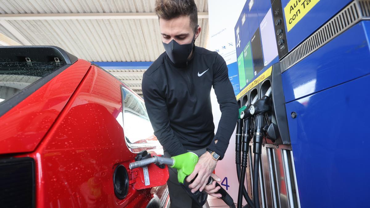 Un joven llena el depósito de combustible en una gasolinera de Castelló.