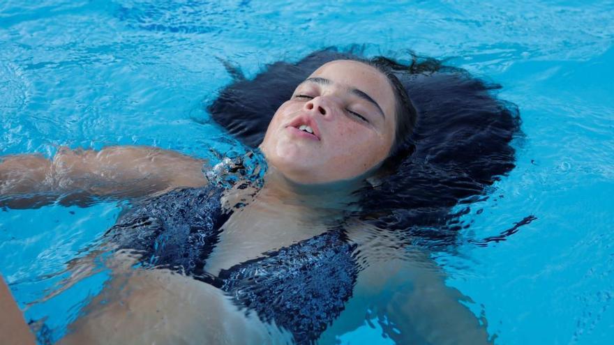 Ein Mädchen erfrischt sich in einem Pool auf Mallorca.