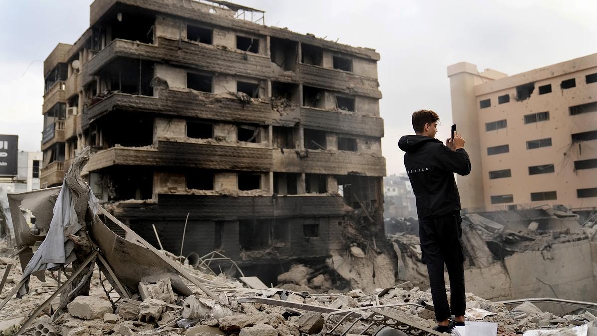 Un hombre toma fotos con el móvil de edificios destruidos tras un ataque aéreo de Israel en Dahiyeh, Beirut, Líbano.