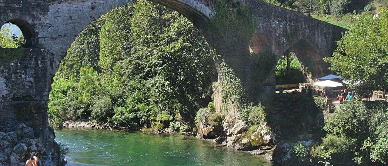 Un joven, a punto de tirarse al Sella desde el Puentón de Cangas de Onís.