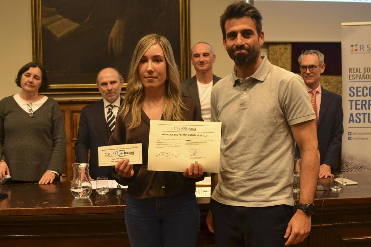 Noelia Delgado, mujer de Jorge González-Rodríguez, investigador premiado, y el profesor Juan Mangas recogiendo la distinción.