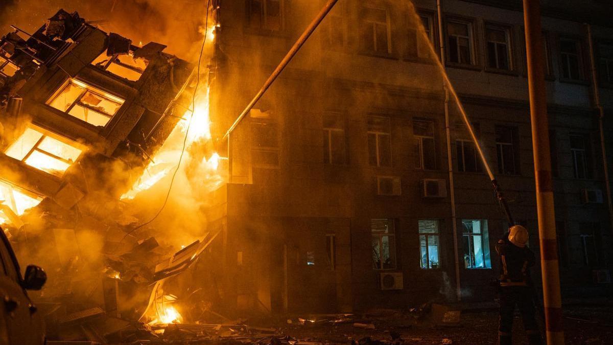 Bomberos ucranianos intentando apagar las llamas en un edificio alcanzado por misiles enviados desde Rusia.