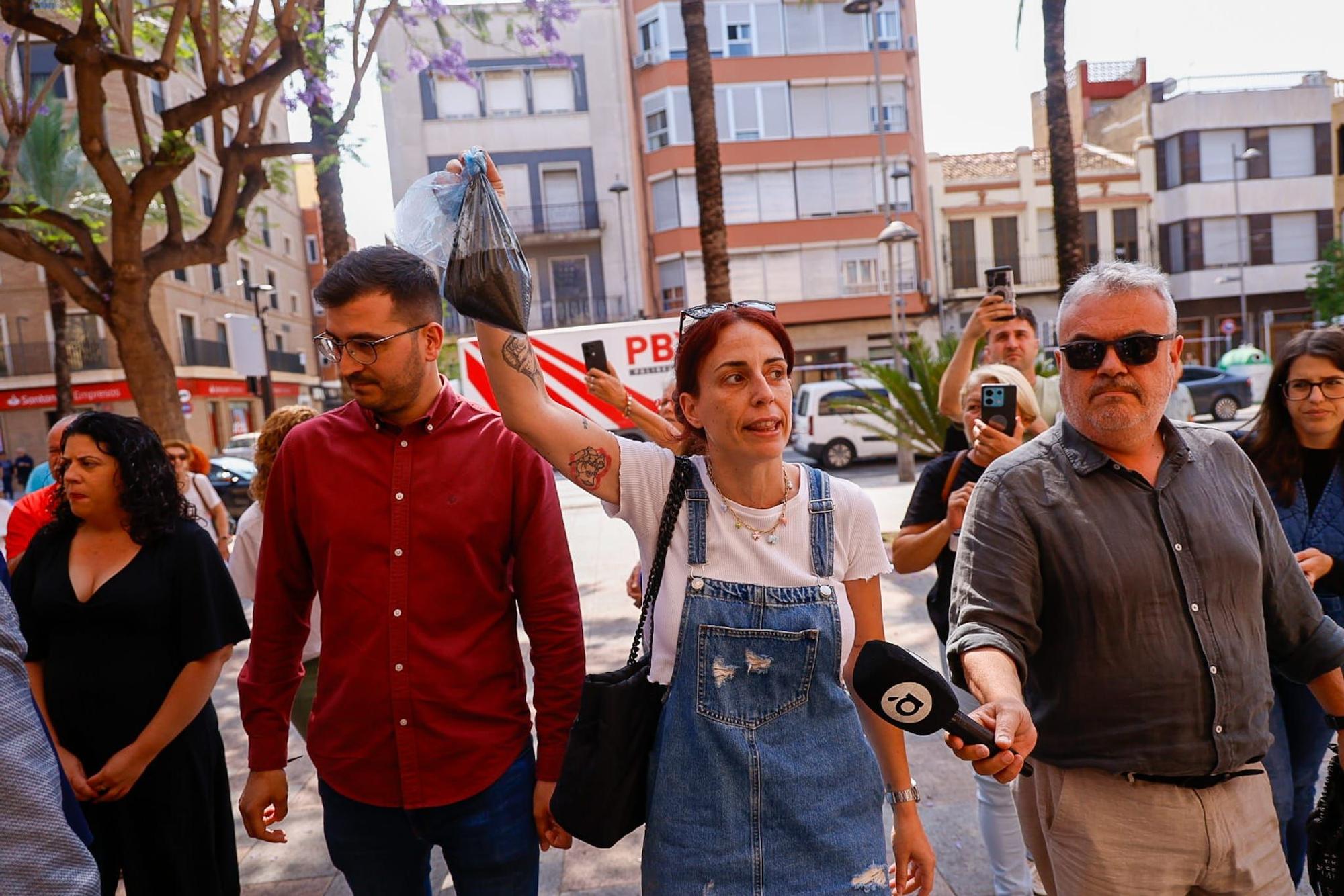 Una vecina de Catarroja lleva una bolsa de fango de la dana a la visita del ministro y Bernabé