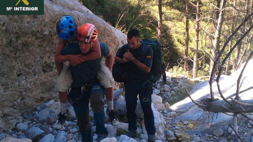 Fotografía facilitada por la Guardia Civil de dos miembros de Rescate del instituto armado que ayudan a rescatar a Mary Ann Goossens, la turista holandesa de 48 años que había desaparecido en Nerja el 17 de junio.