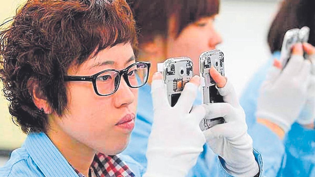 Un técnico de una compañía coreana fabricante de teléfonos móviles con IA incorporada revisa el estado de un terminal