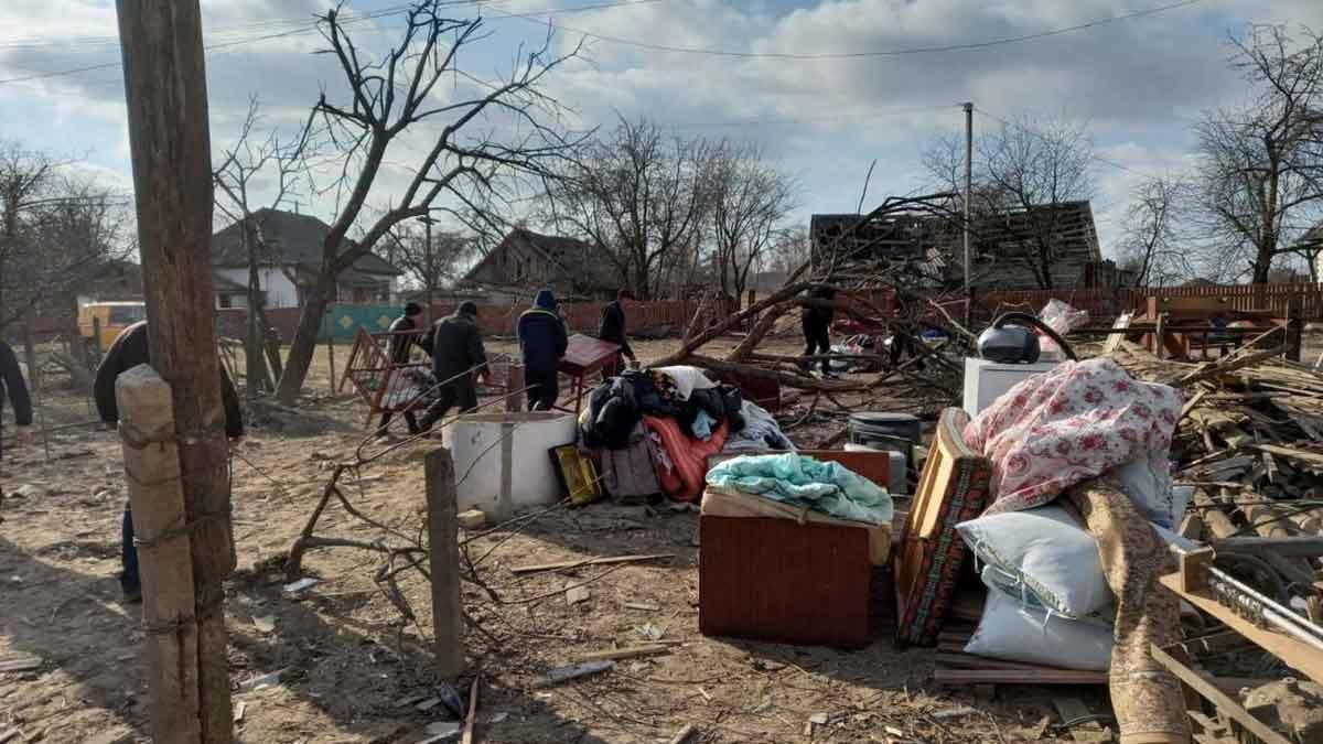 Ciudadanos pasan junto a los escombros de casas dañadas por un bombardeo ruso en la localidad ucraniana de Rakivshchyna.