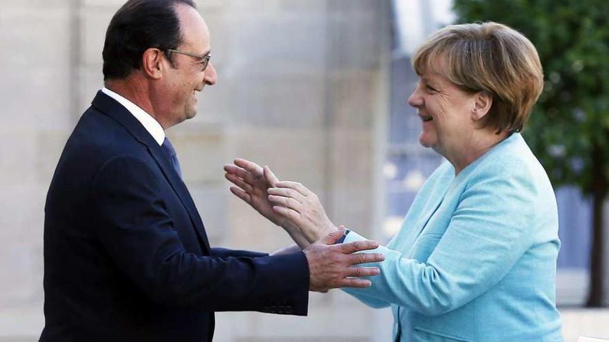 Hollande saluda a Merkel, ayer, a su llegada al palacio del Elíseo.