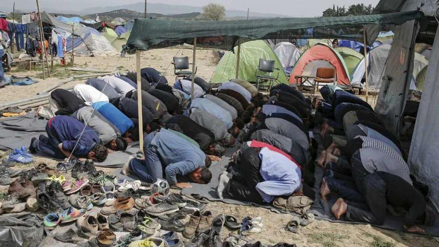 Refugiados, ayer viernes, rezando en Idomeni, en la frontera de Grecia y Macedonia. // Reuters