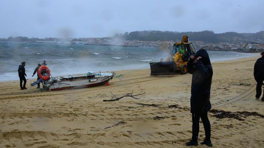 Una retroexcavadora del Concello de Cangas arrastra la planeadora de poliéster en Rodeira, en medio del fuerte temporal.