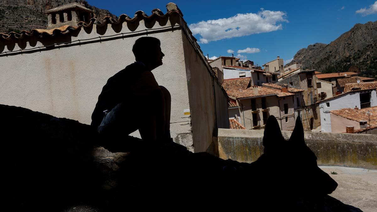 Eloy Moliner, de 12 años, se sienta con uno de sus perros en las calles del pequeño pueblo español de Pitarque, Teruel, Con el cierre de la escuela, Eloy será el único niño dejado en el pueblo. “Qué lástima, la escuela cierra y todo muere”, dice Eloy. 