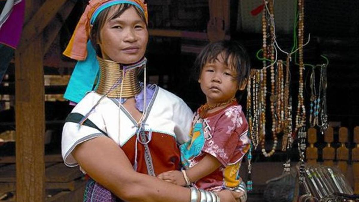 Una madre kayan con su hijo vende suvenires en Ban Mai Nai Soi (Tailandia).