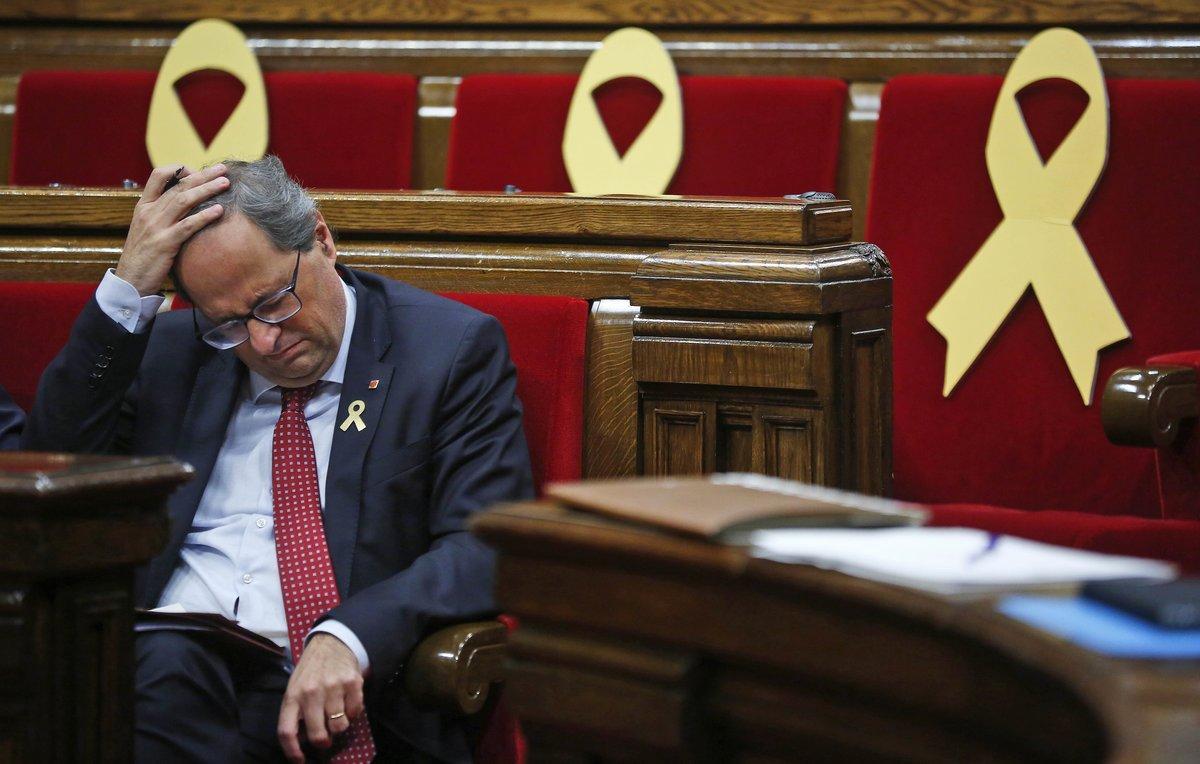 Catalan regional President Quim Torra puts his hand on his head during a parliamentary session, in Barcelona, Spain, Wednesday, Oct. 3, 2018. Torra issued an ultimatum to Spanish Prime Minister Pedro Sanchez on Tuesday over the wealthy northeastern region’s future but it was promptly rejected by the Spanish government. Yellow ribbons on the seats are in support of Catalonian politicians who have been jailed on charges of sedition. (AP Photo/Manu Fernandez)