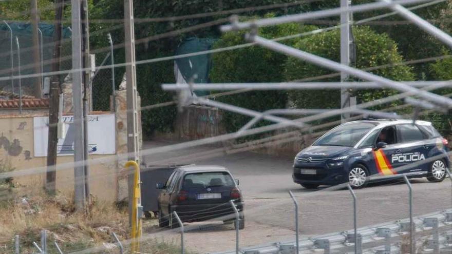 Una patrulla de la Policía permanece en una de las entradas a la calle de Las Llamas.