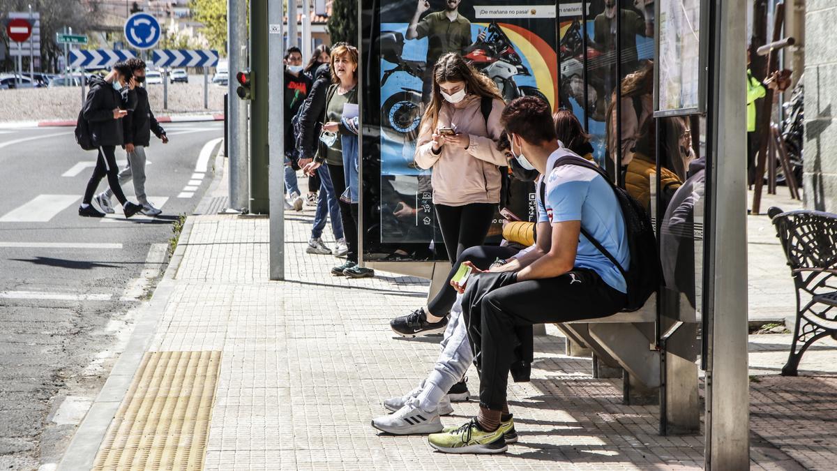 Un grupo de jóvenes esperan el autobús urbano en una de las paradas que hay en la ciudad.