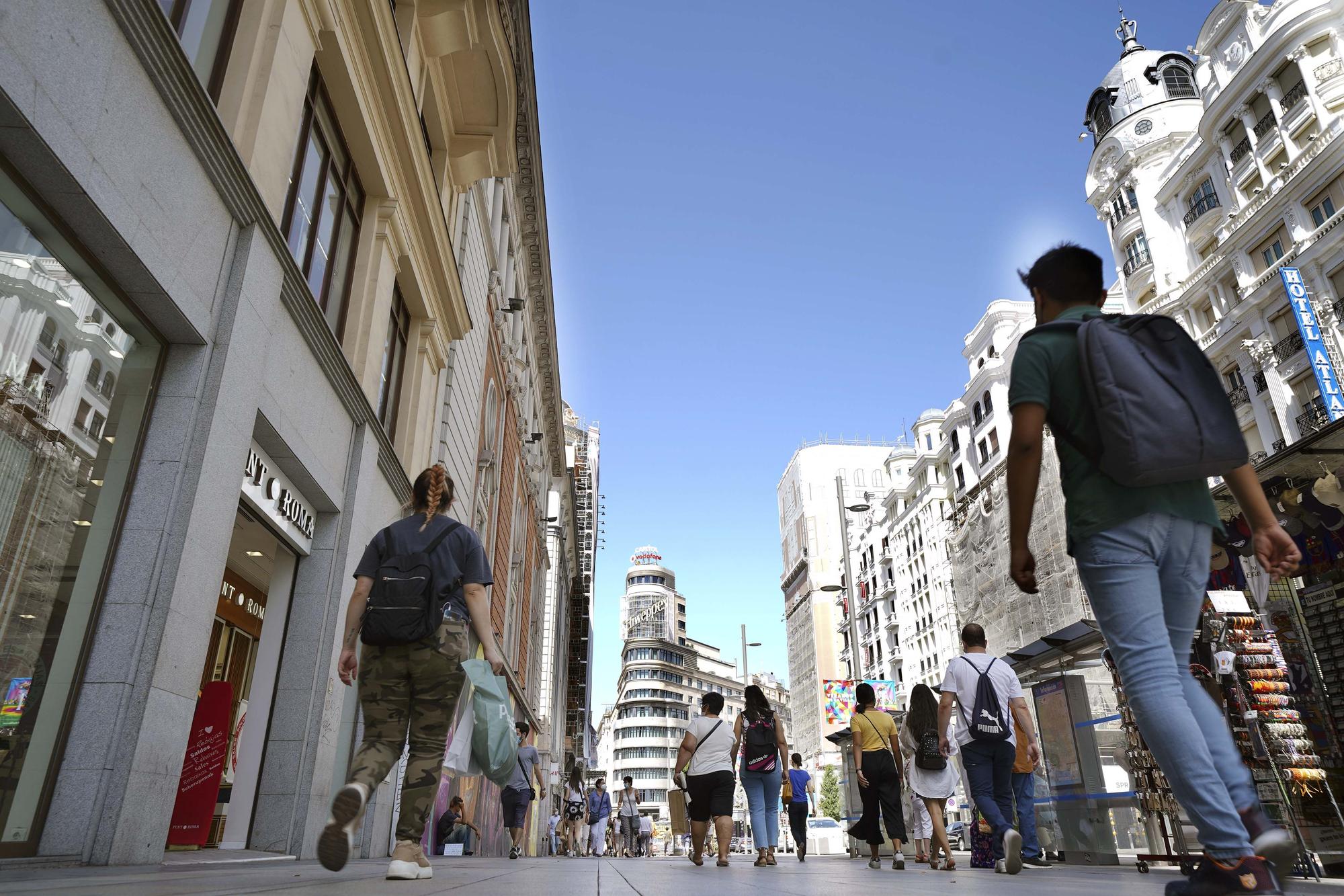 Varias personas caminan por el centro de Madrid, en la imagen la Gran Vía.