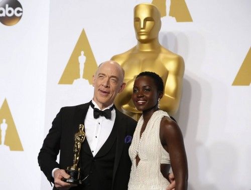 Simmons, winner of the award for best supporting actor for his role in "Whiplash", poses with presenter Nyong'o during the 87th Academy Awards in Hollywood, California