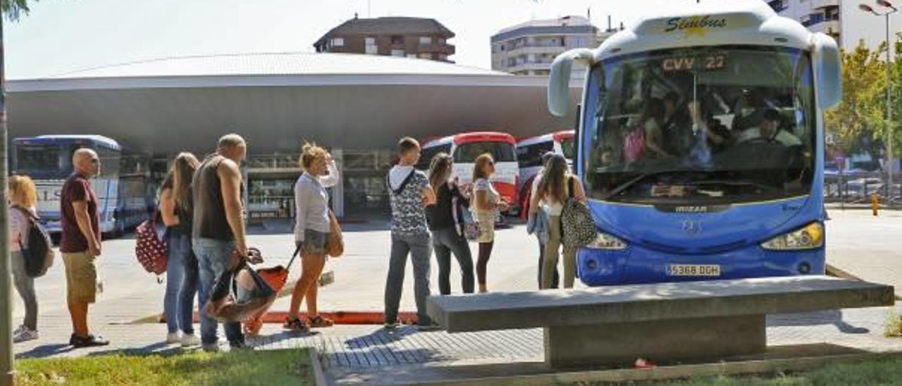 Un grupo de personas hace cola para subir a un autobús interurbano en la estación de Gandia.