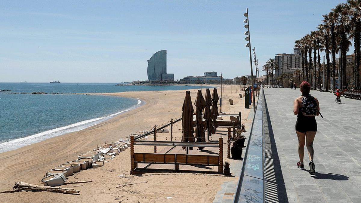 Una mujer camina por el paseo marítimo de Barcelona, el 6 de mayo