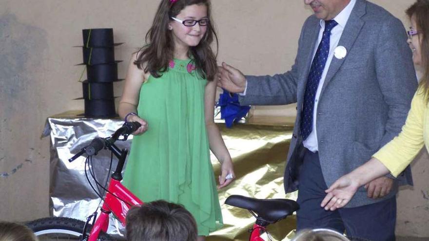La niña recibe feliz la bicicleta de manos de un representante de Serunión.