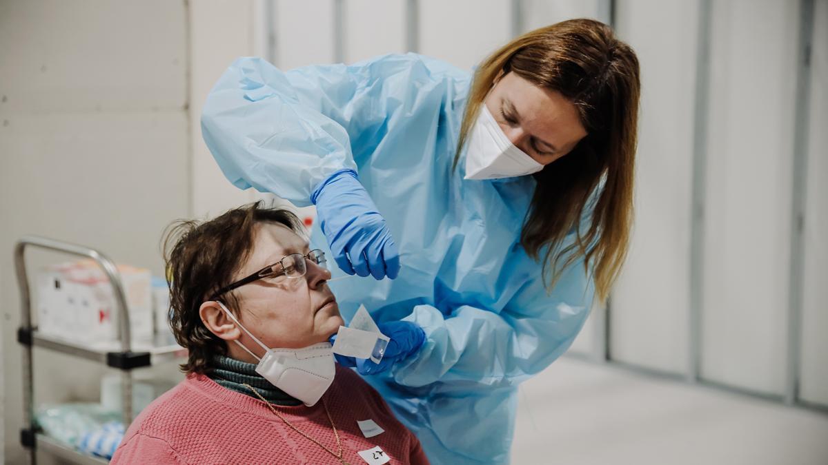 Archivo - Una sanitaria realiza pruebas Covid a personas refugiadas, a su llegada al Hospital Isabel Zendal, a 16 de marzo de 2022