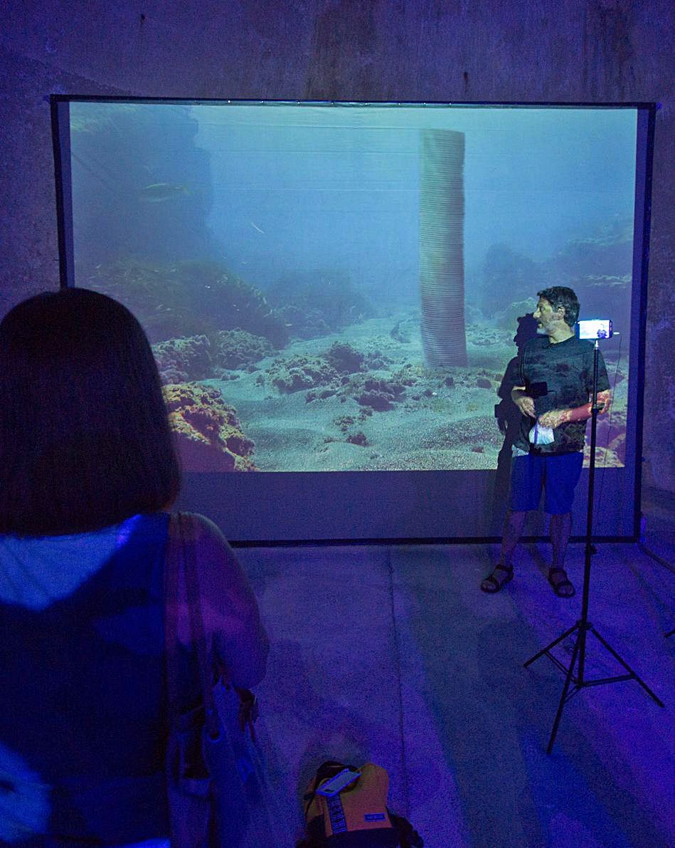 El artista Aurelio Ayela frente a una videoproyección en los Pozos de Garrigós |