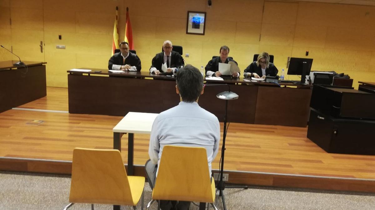 L'acusat, d'esquenes, durant el judici a l'Audiència de Girona.