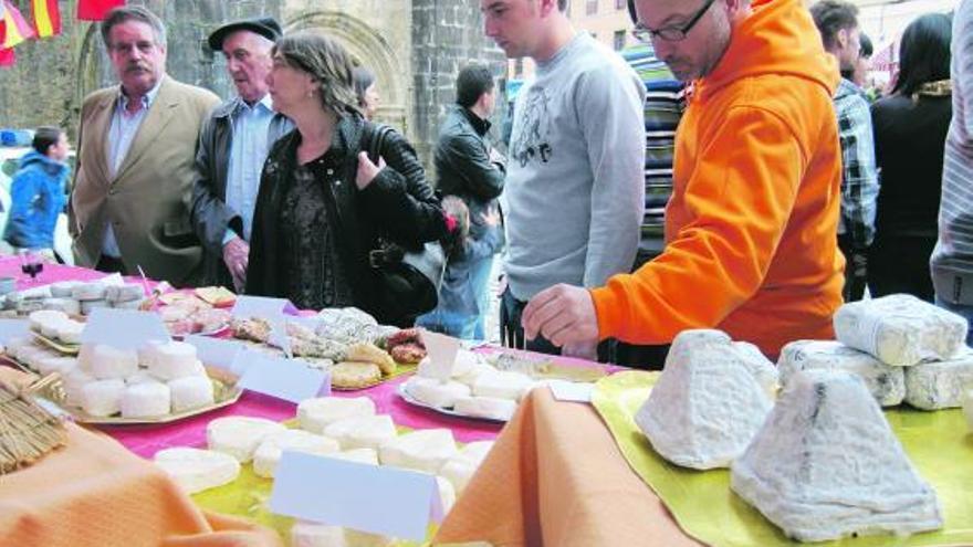 Público en el expositor de queso francés. A la derecha, otro de los puestos de quesos asturianos del certamen celebrado ayer en Salas. / L. valdés
