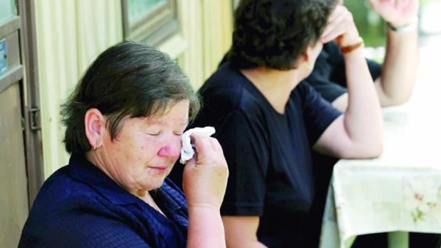 Varias mujeres lloran frente a la casa de una de las víctimas del tiroteo.