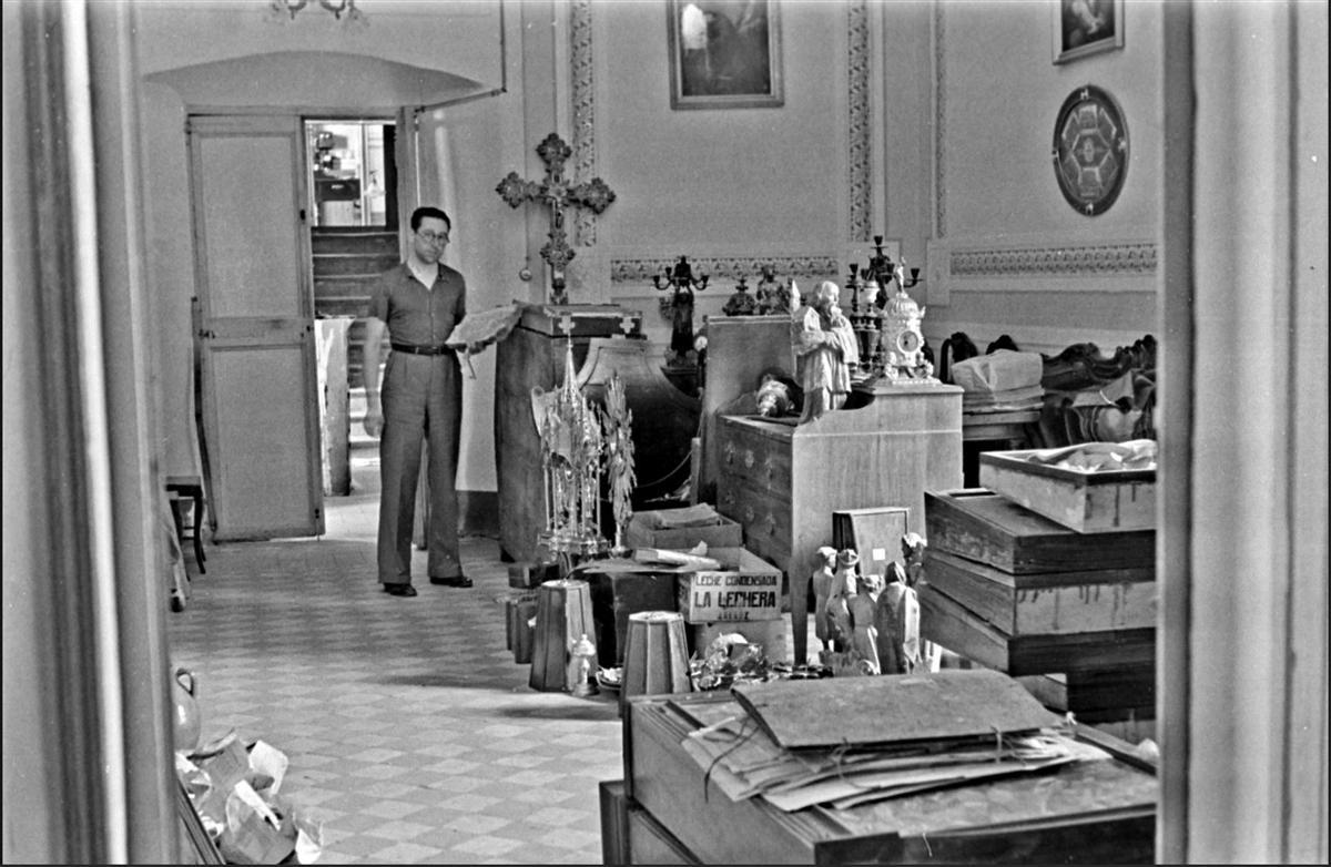 Un tècnic fent recompte de les obres artístiques dipositades a can Descals de Darnius, l'any 1938.