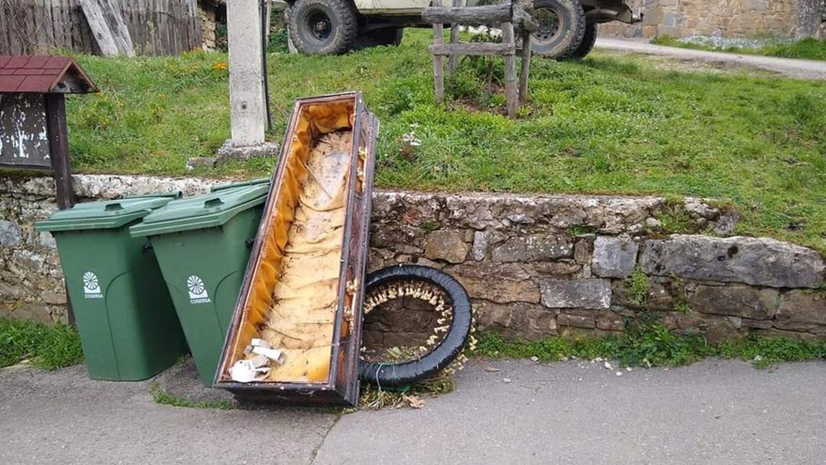 Ataúd abandonado junto a la basura