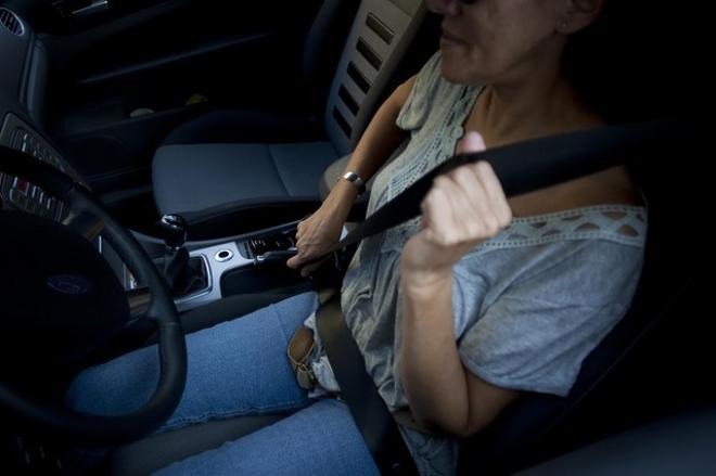 Imatge d’una conductora col·locant-se un cinturó de seguretat.