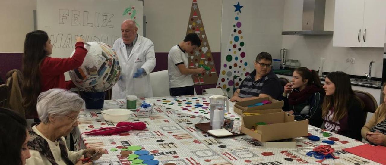 Alumnos del centro realizando la decoración navideña junto a mayores del centro sociosanitario.