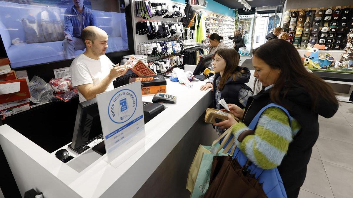 Clientes en una tienda pagando durante la campaña del Bono Comercio de la Xunta de Galicia.