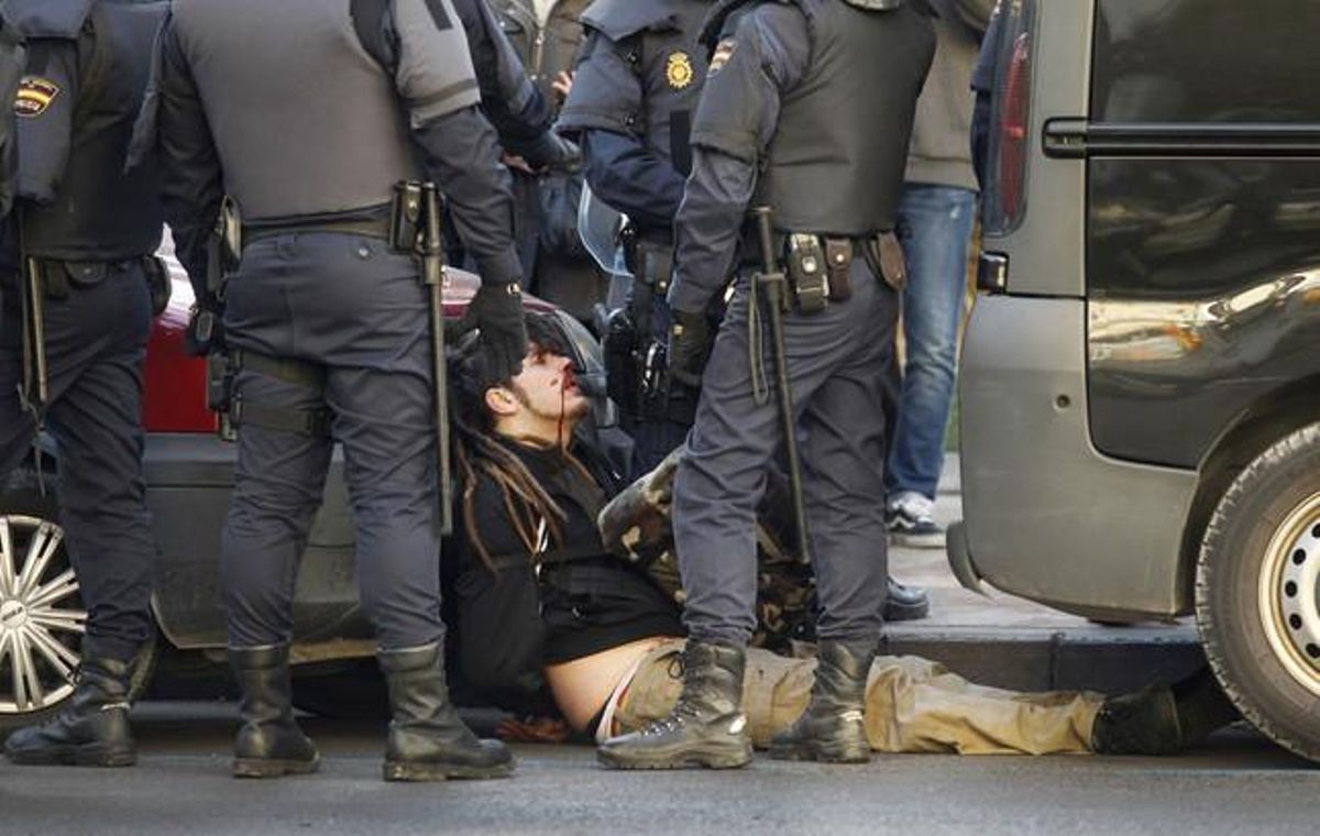 Els agents de la policia detenen& un manifestant ferit.