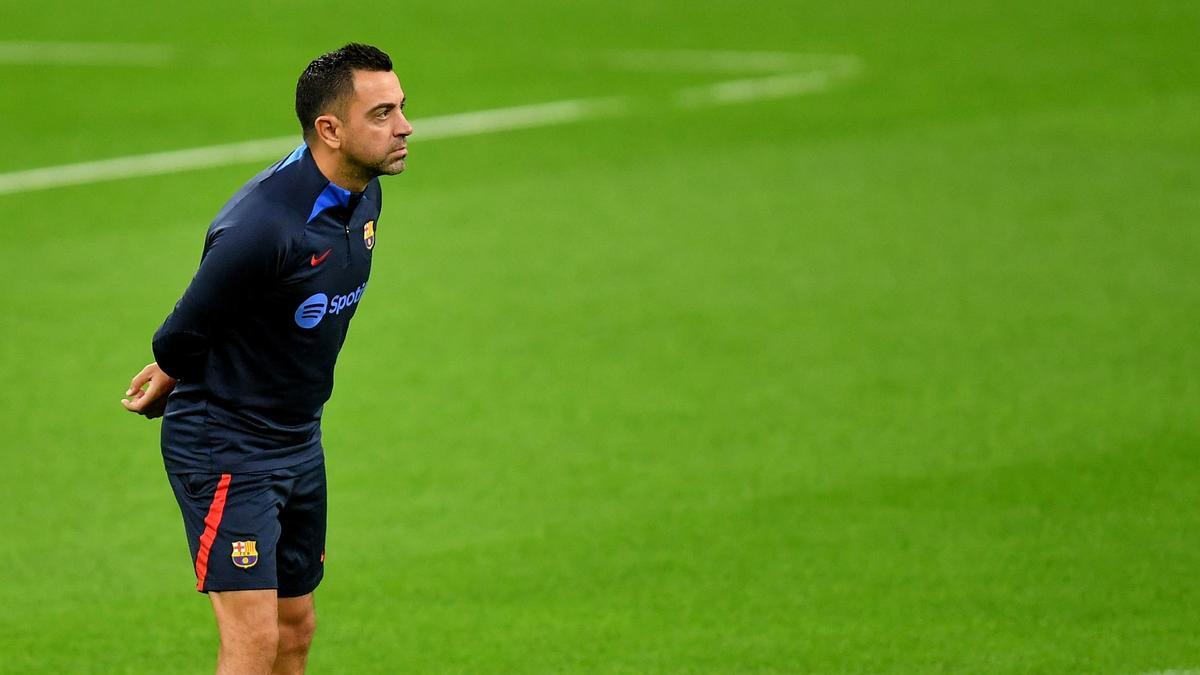 Xavi Hernández, sobre el césped de San Siro, siguiendo el entrenamiento del Barça.