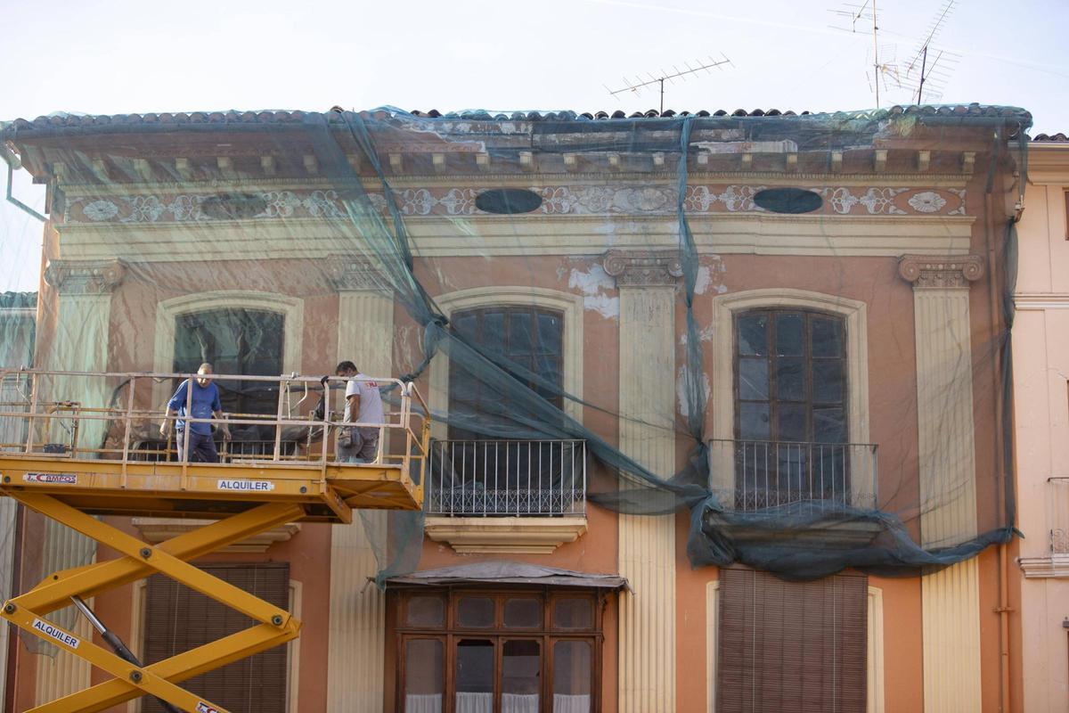Unos obreros sanean una fachada en una casa de Xàtiva, en una imagen de archivo.