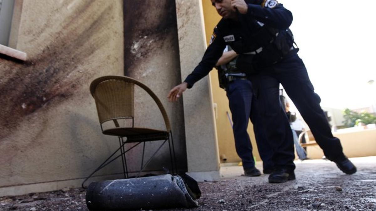 Policías israelís examinan los restos del cohete que ha impactado en Sderot.