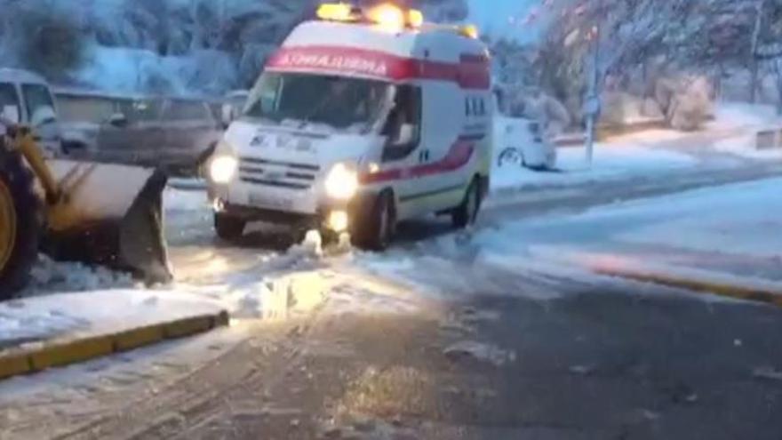 Una excavadora remolca  a una ambulancia en el hospital de Requena por la nieve